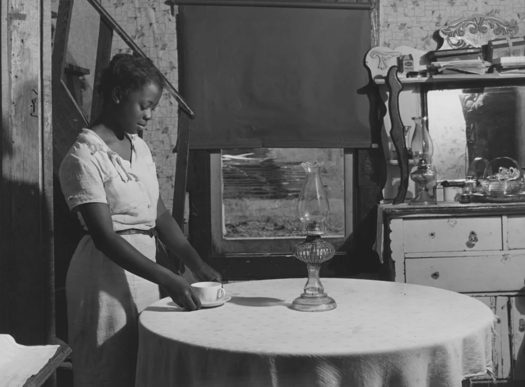 A housekeeper arranging the bed linens in an elegant hotel room.